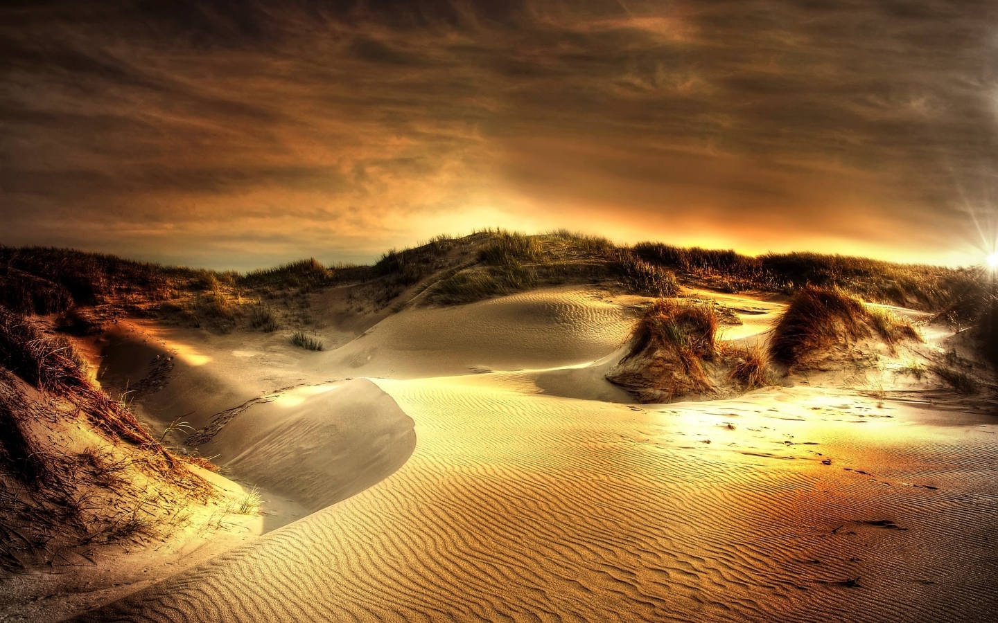 Волнистый песок под красивым небом на закате