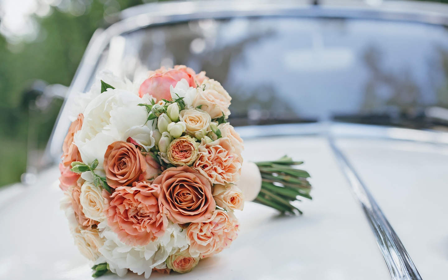 Свадебный букет роз лежит на машине