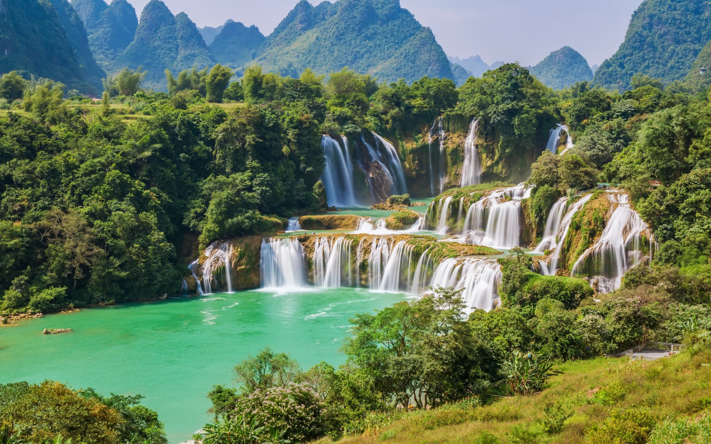 Водопад стекает с гор на фоне зеленой природы