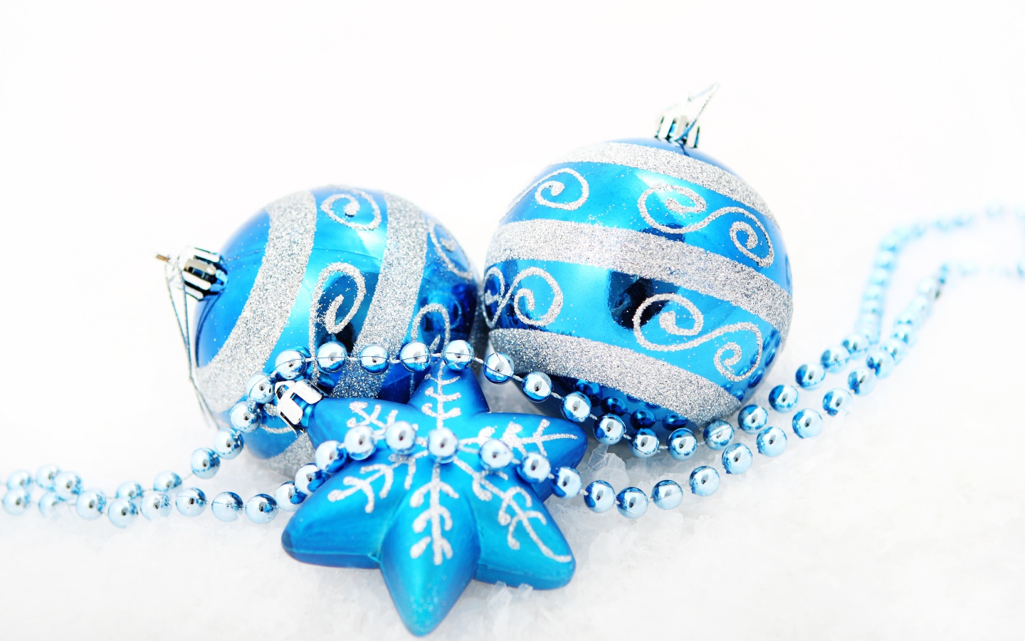 Красивые голубые елочные шарики со звездой и бусами на белом фоне