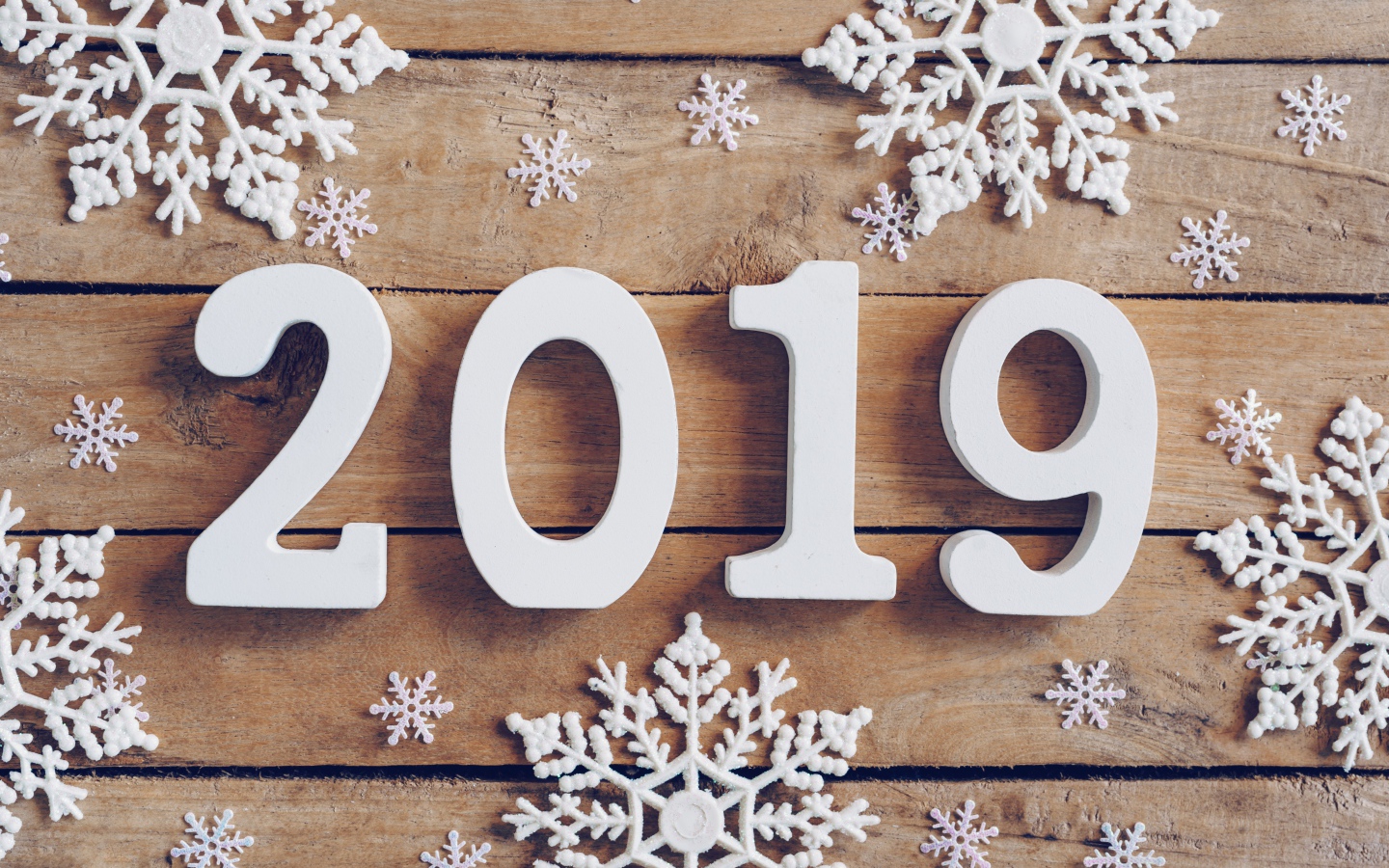 Белые цифры 2019 на деревянном столе с белыми снежинками