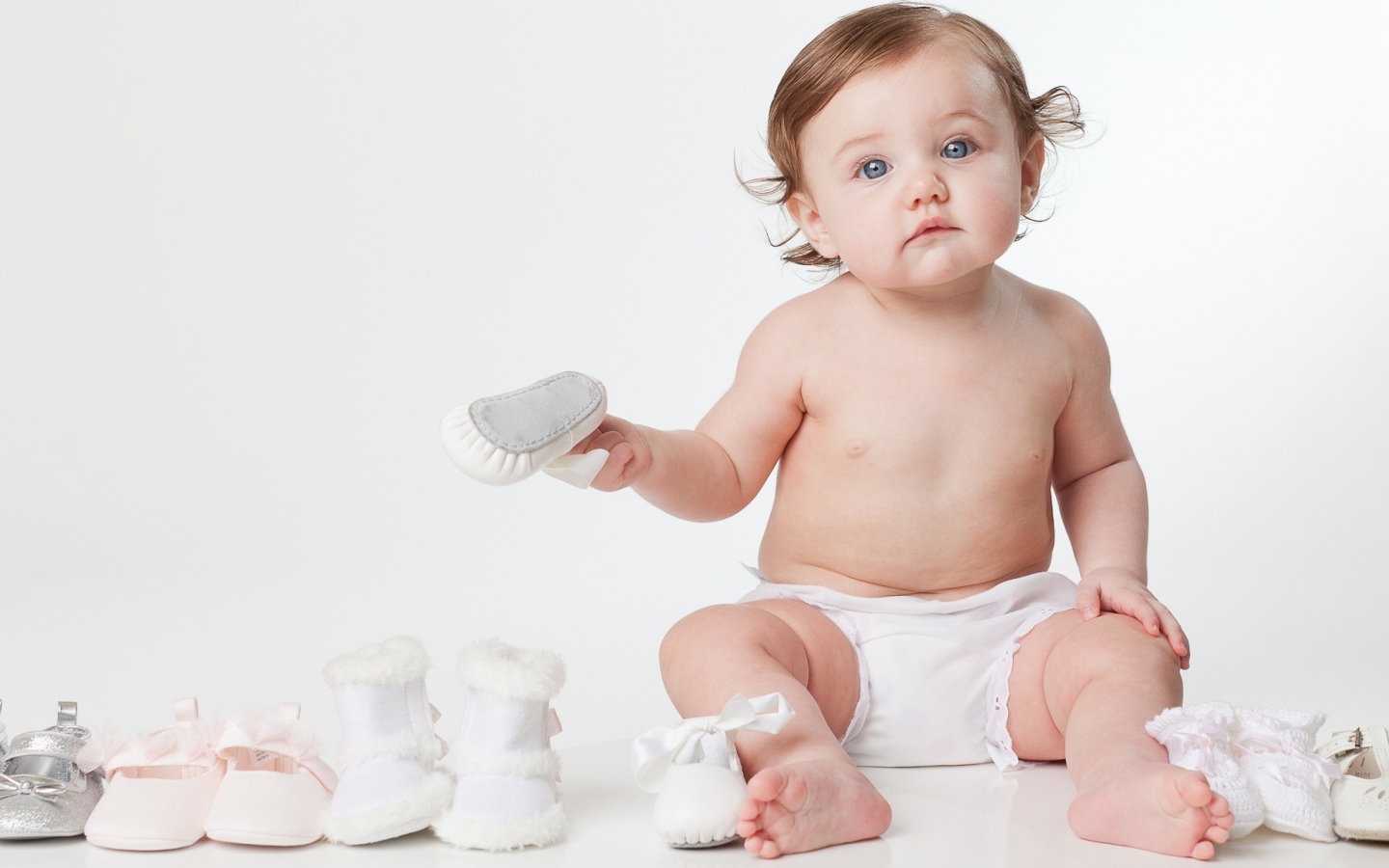 Маленький грудной ребенок с детской обувью