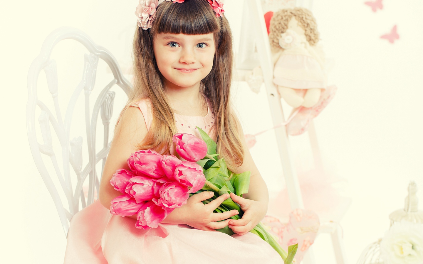 Красивая милая голубоглазая девочка с букетом розовых тюльпанов