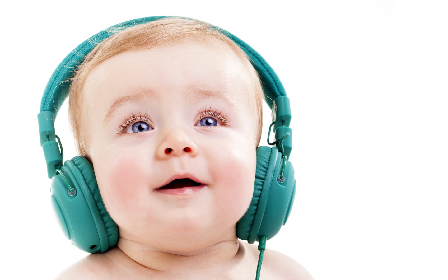 Милый младенец в больших наушниках на белом фоне