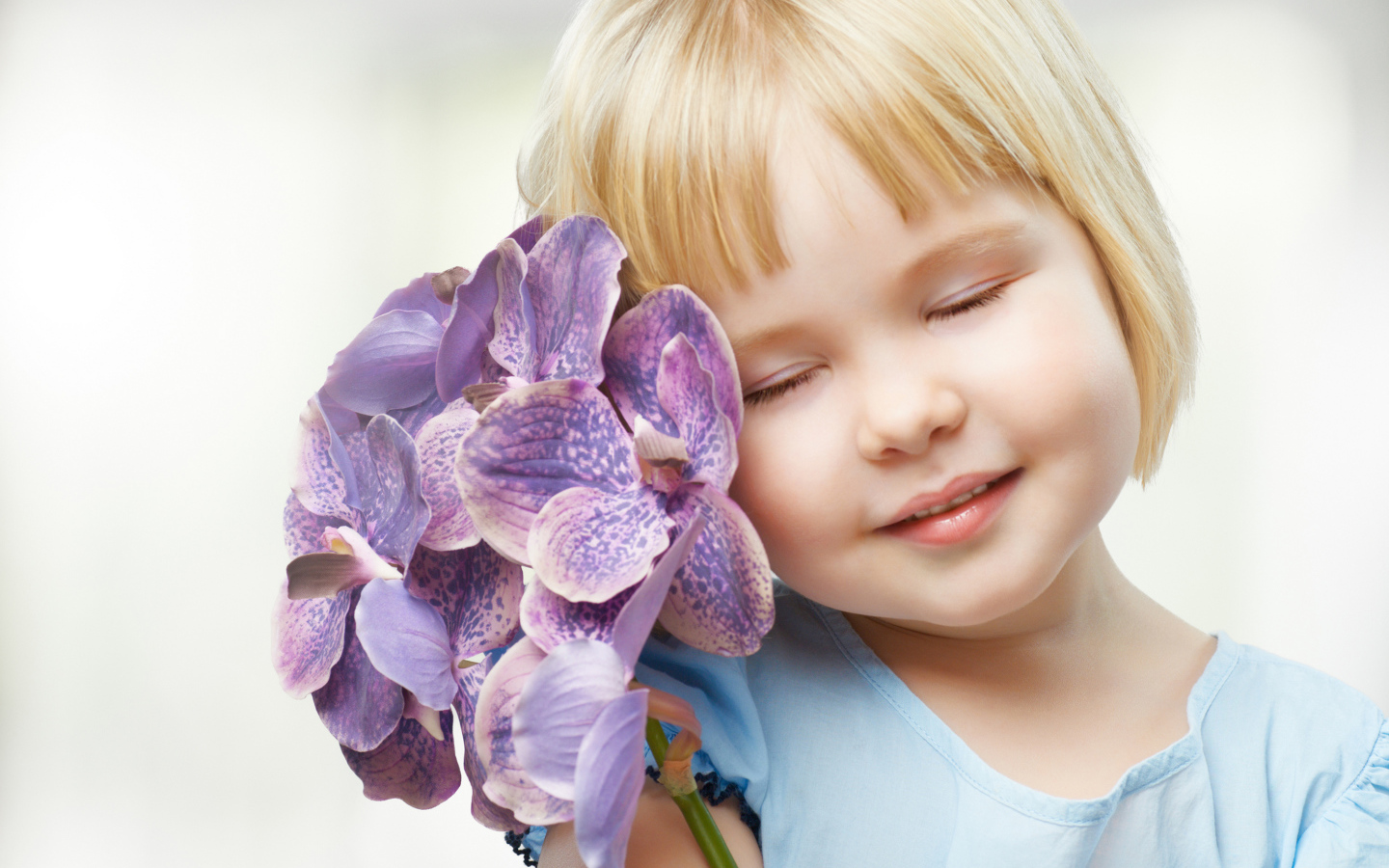 Маленькая девочка блондинка с цветами орхидеи