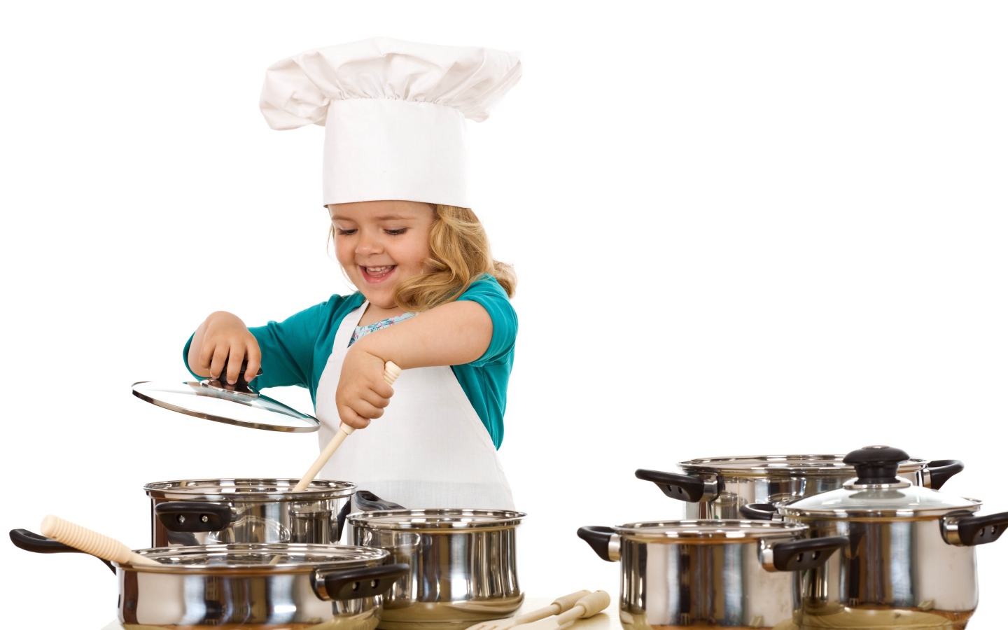 Маленькая девочка в костюме повара на кухне