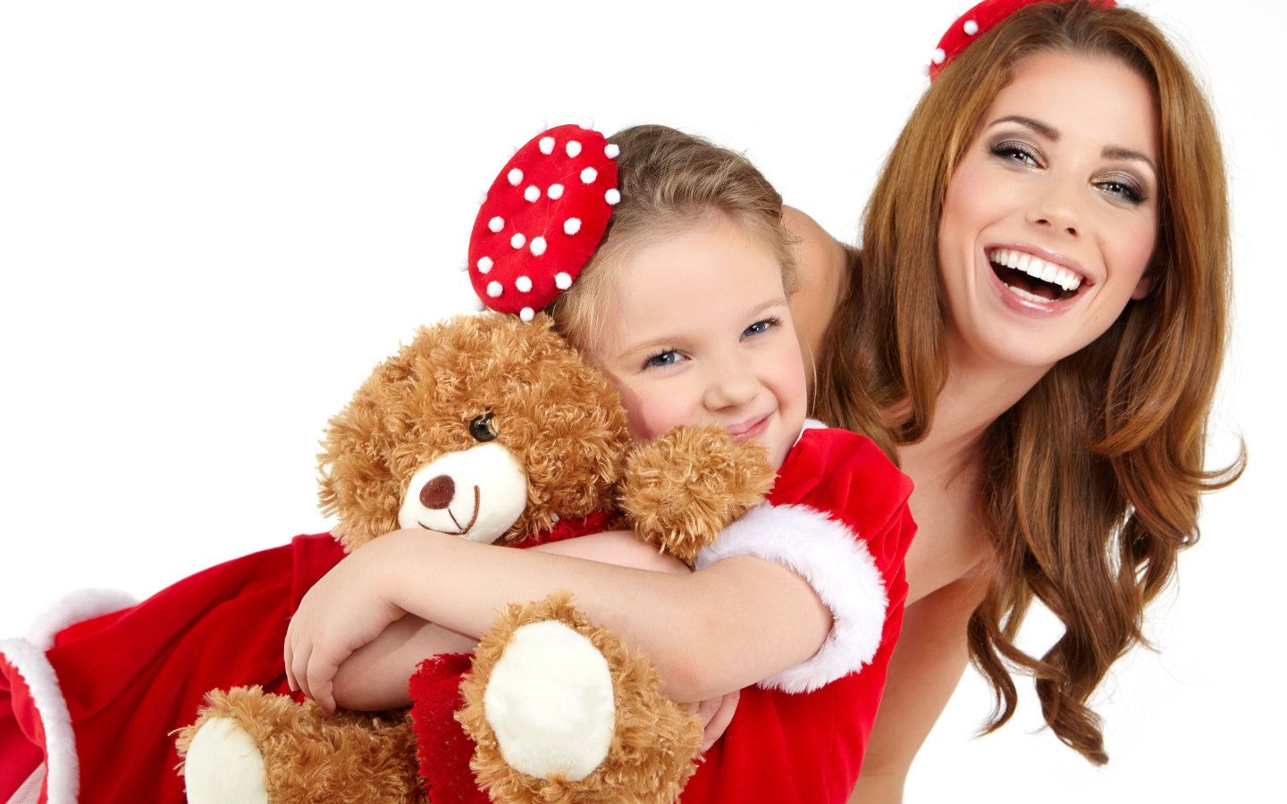 Маленькая девочка с мамой обнимает игрушечного медвежонка