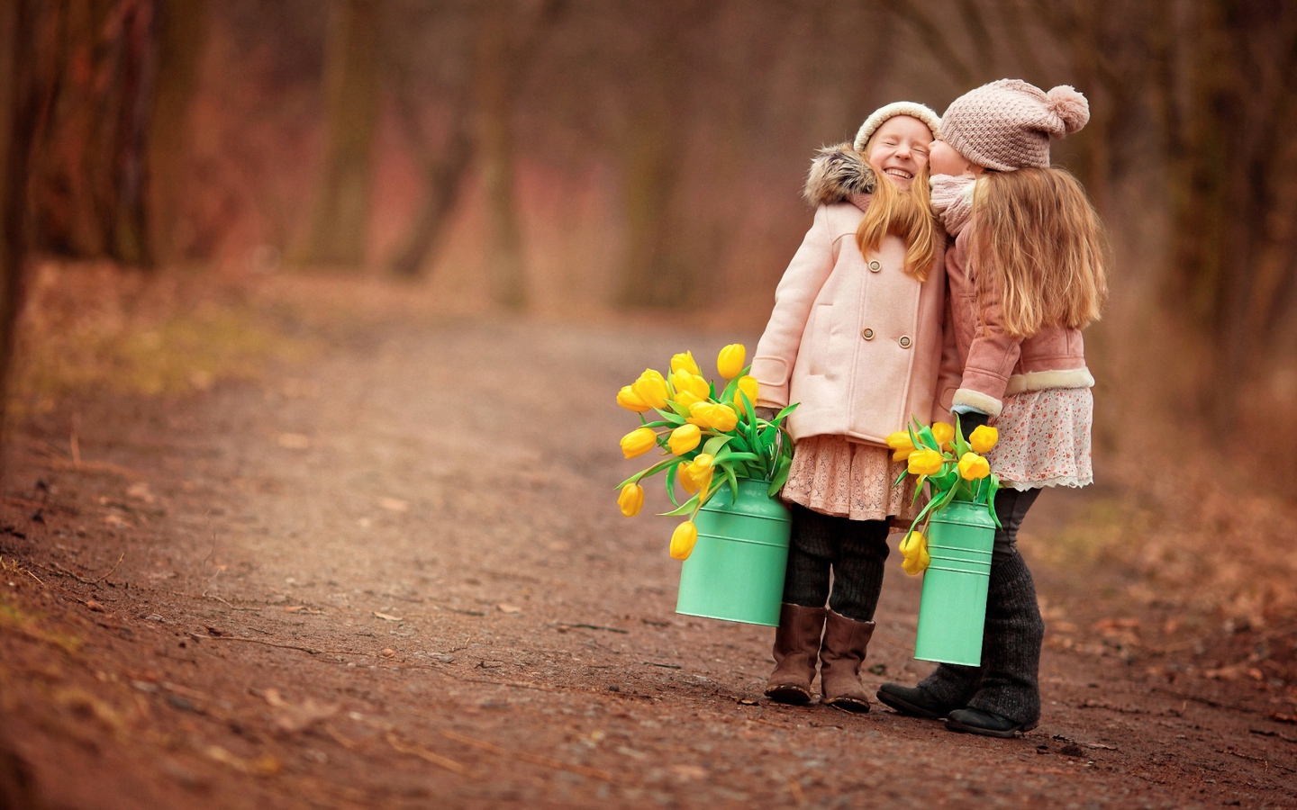 Две маленькие девочки с желтыми тюльпанами весной