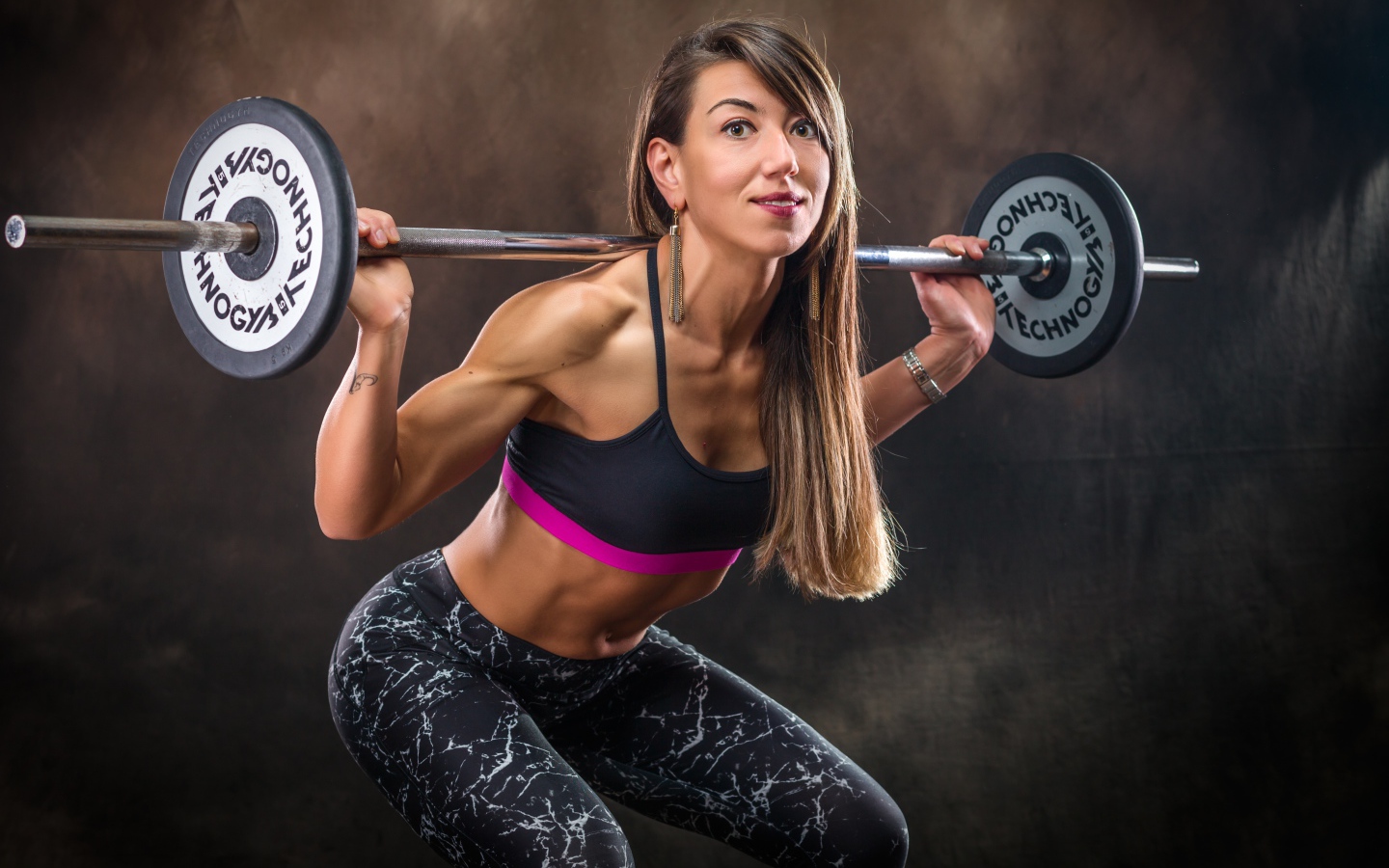 Спортивная накаченная девушка со штангой 