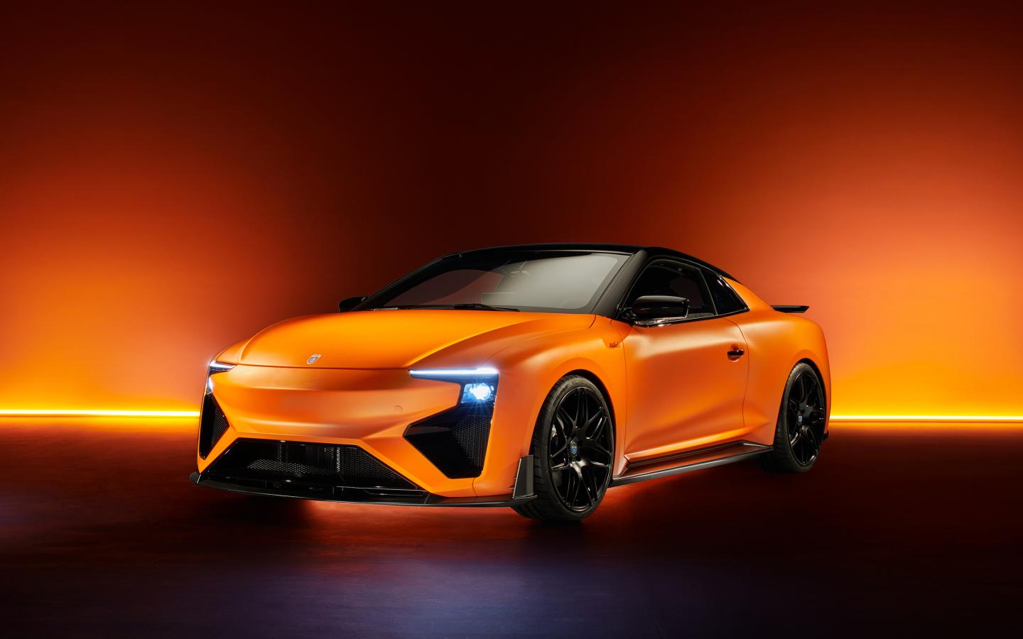 Оранжевый автомобиль Gumpert RG Nathalie 2019 года с включенными фарами