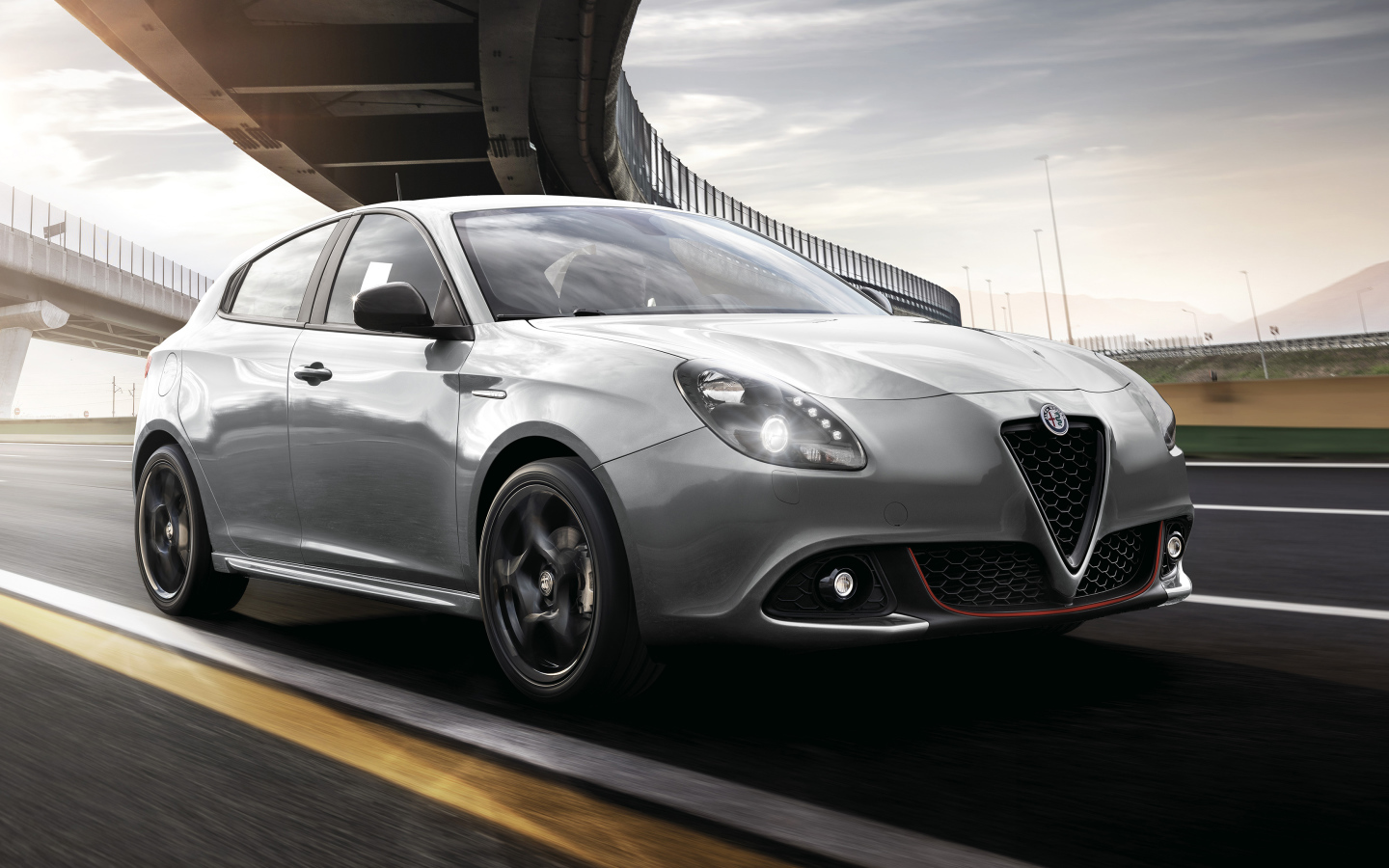 Серебристый автомобиль Alfa Romeo Giulietta Sport 2019 года под мостом