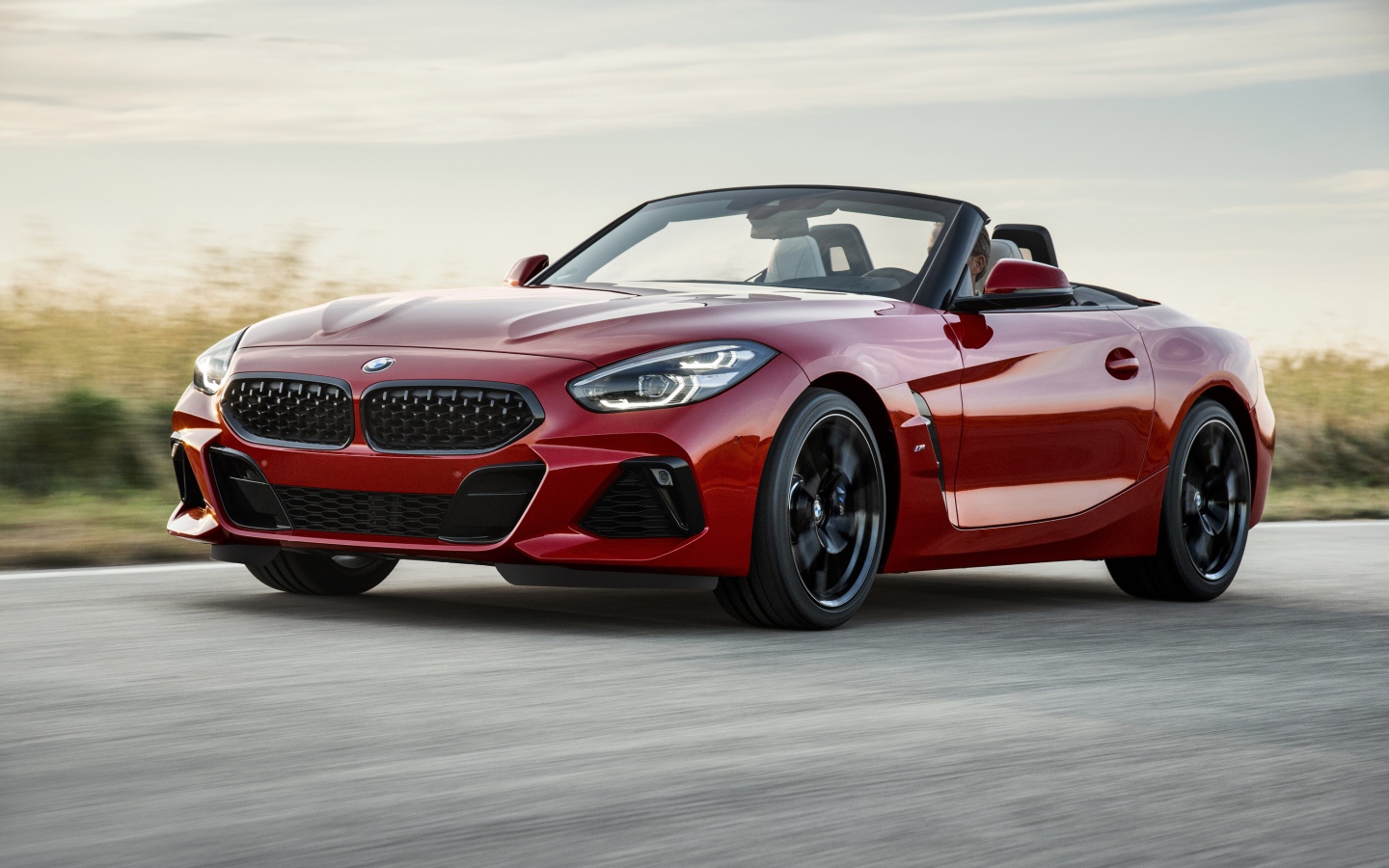 Красный автомобиль кабриолет BMW Z4 на дороге