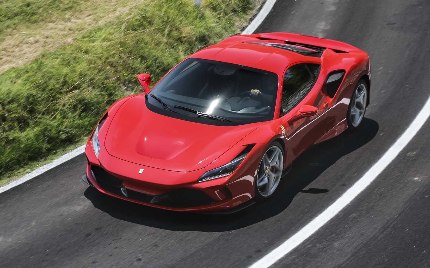 Красный автомобиль Ferrari F8 Tributo 2019 года на дороге