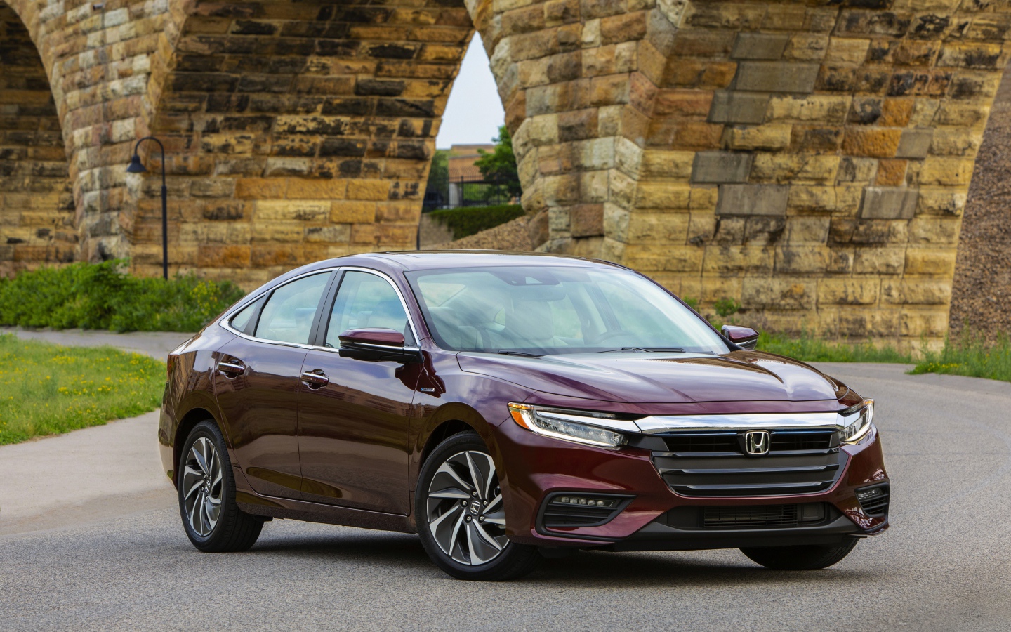 Бордовый автомобиль Honda Insight у моста