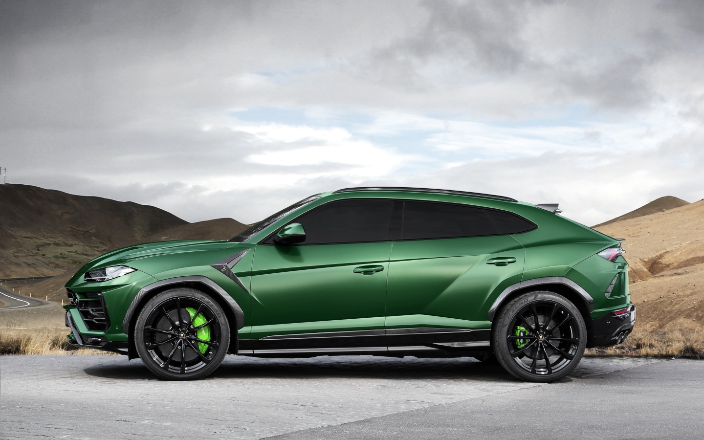 Зеленый автомобиль Lamborghini Urus вид сбоку