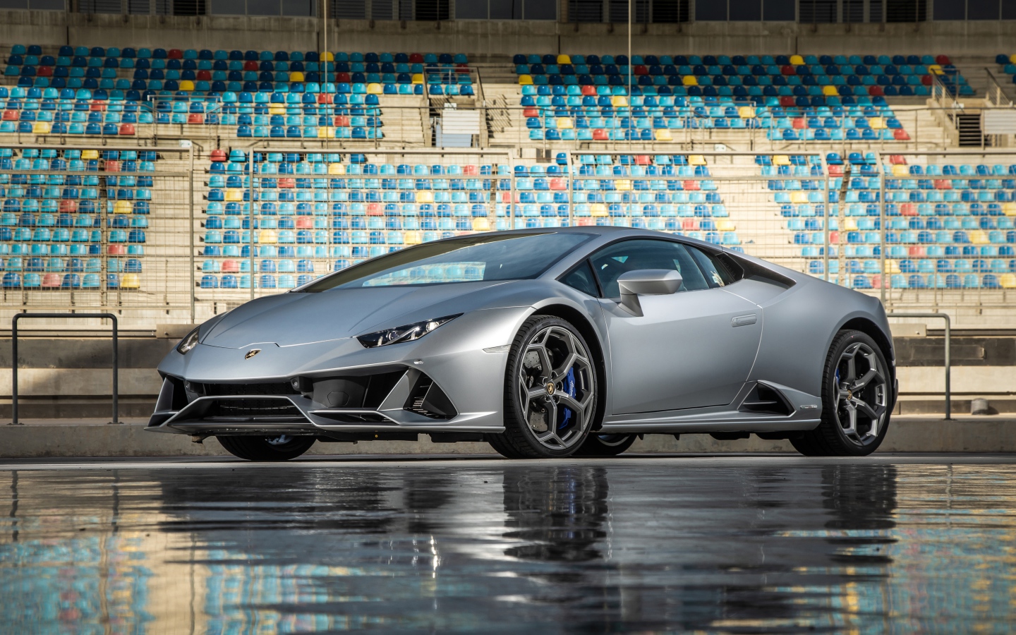 Серебристый автомобиль Lamborghini Huracan Evo на стадионе