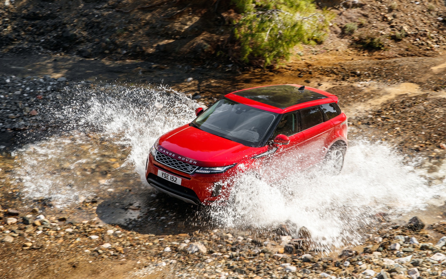 Красный внедорожник Range Rover Evoque D240 S 2019 года едет по воде