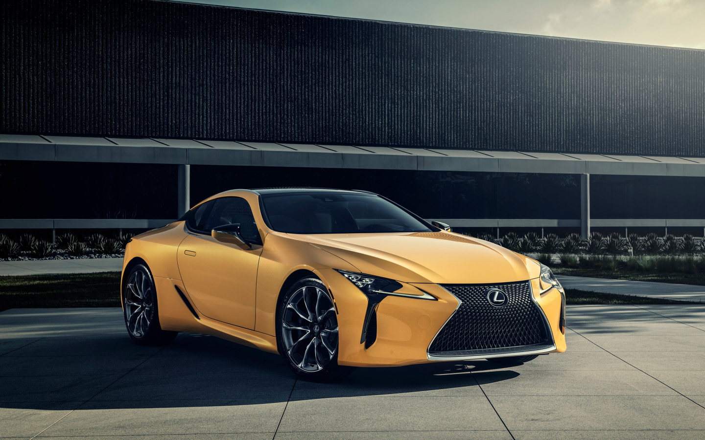 Желтый автомобиль Lexus LC 500 на фоне стены