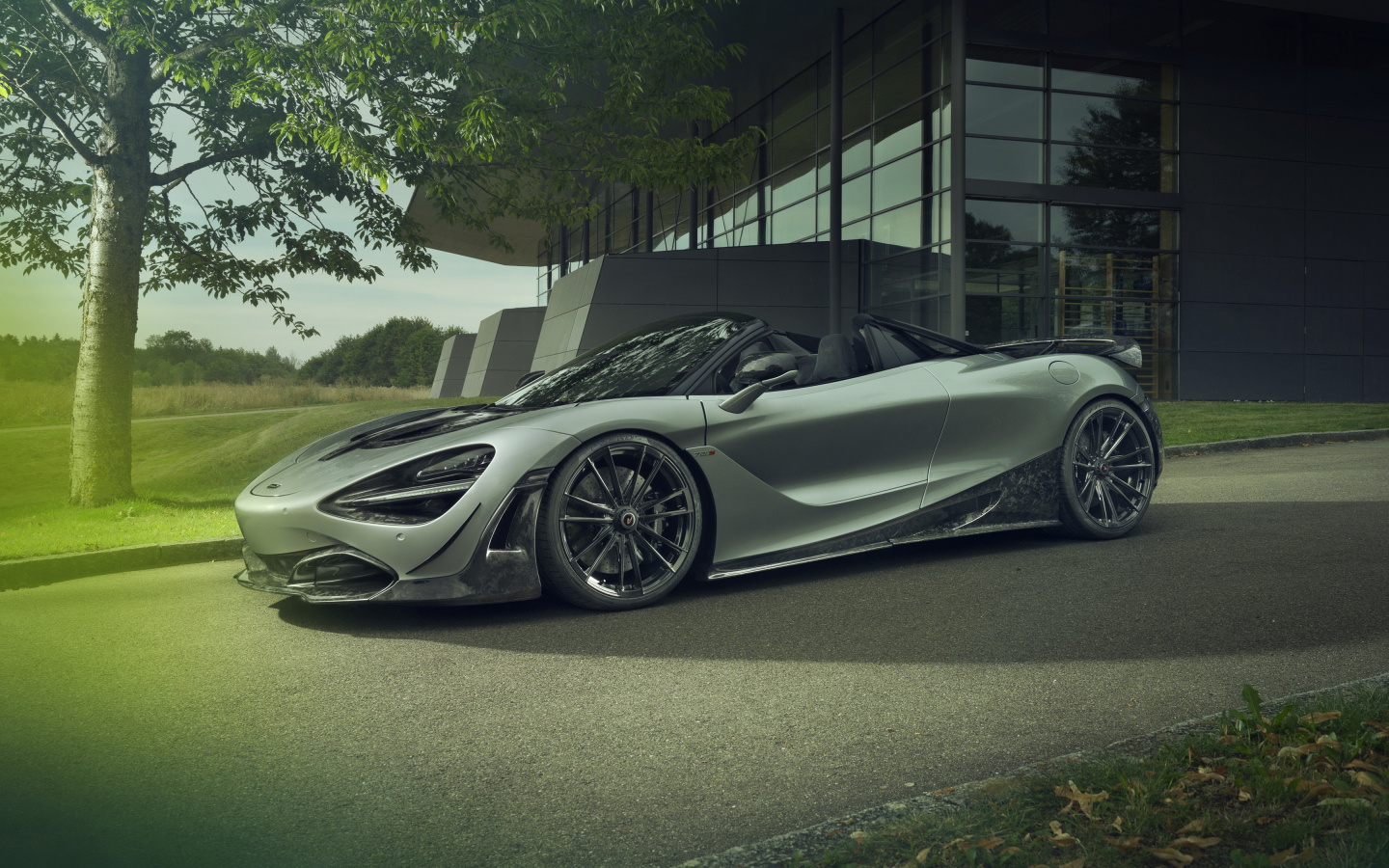 Серебристый автомобиль McLaren 720S Spider 2019 года у дома