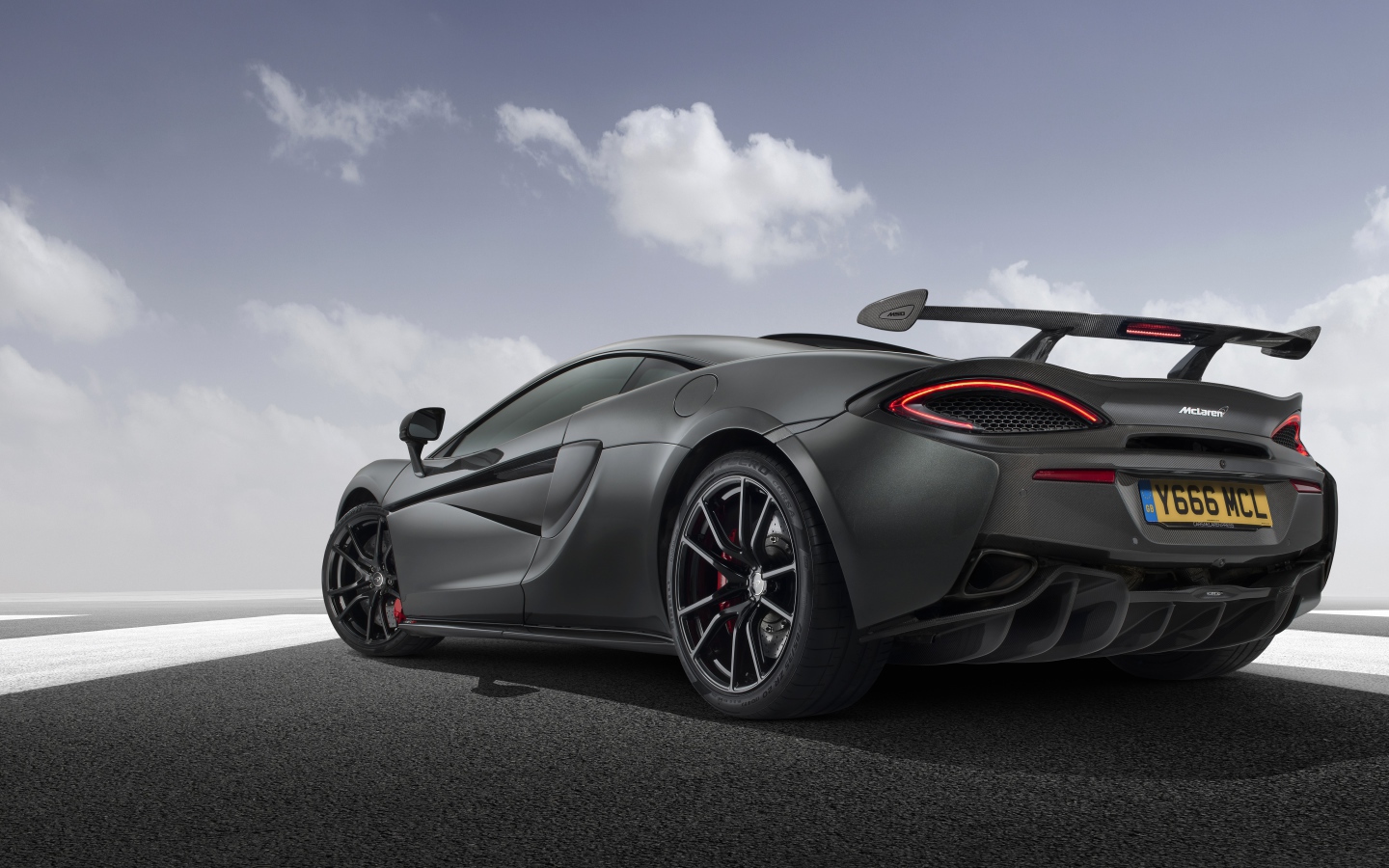 Серебристый автомобиль McLaren 720S вид сзади