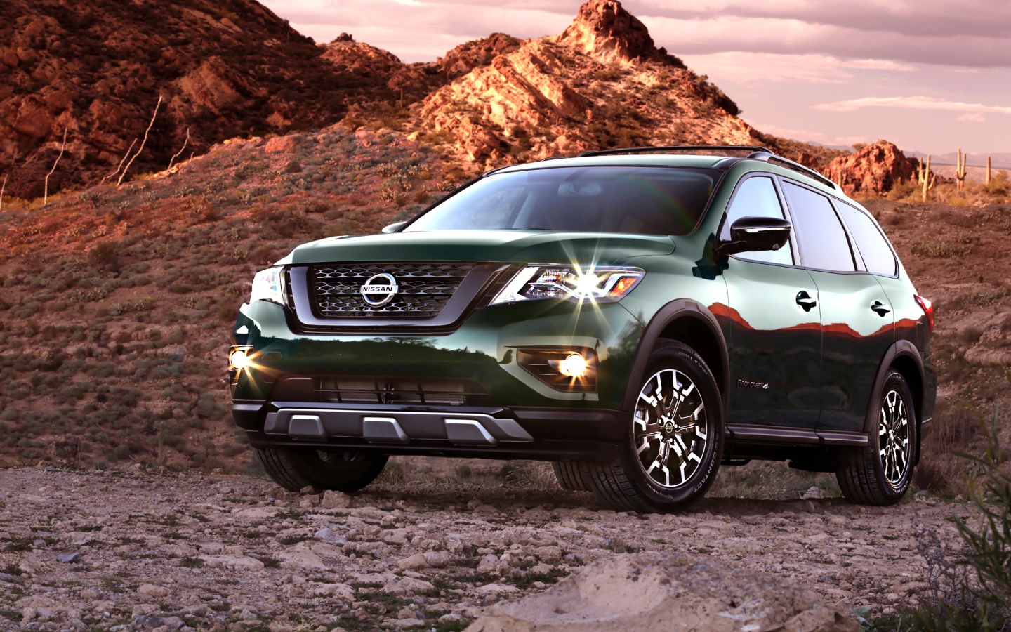 Зеленый автомобиль Nissan Pathfinder в горах 