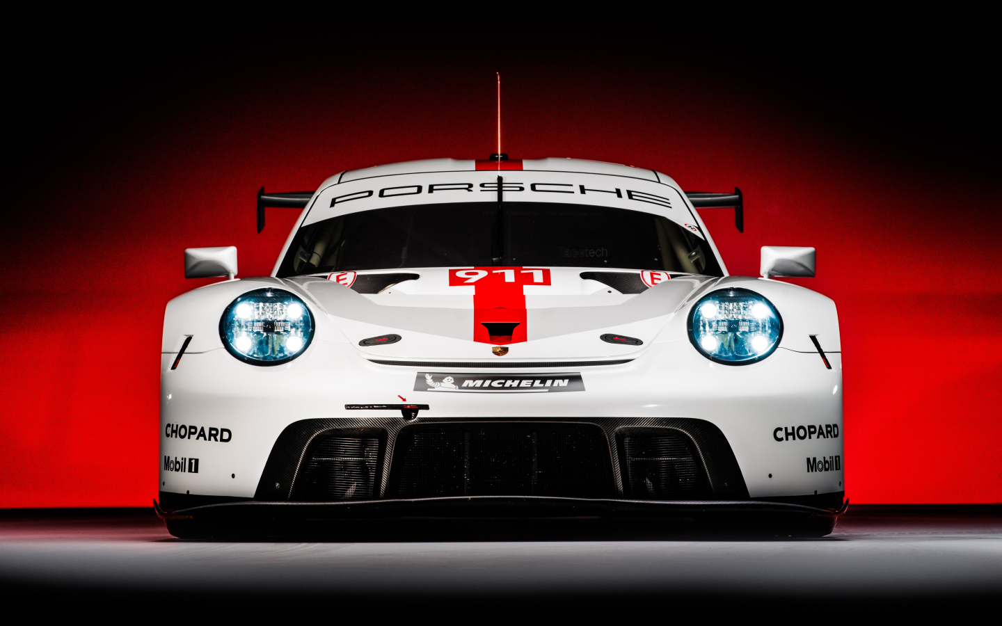 Спортивный автомобиль Porsche 911 RSR 2019 года на красном фоне