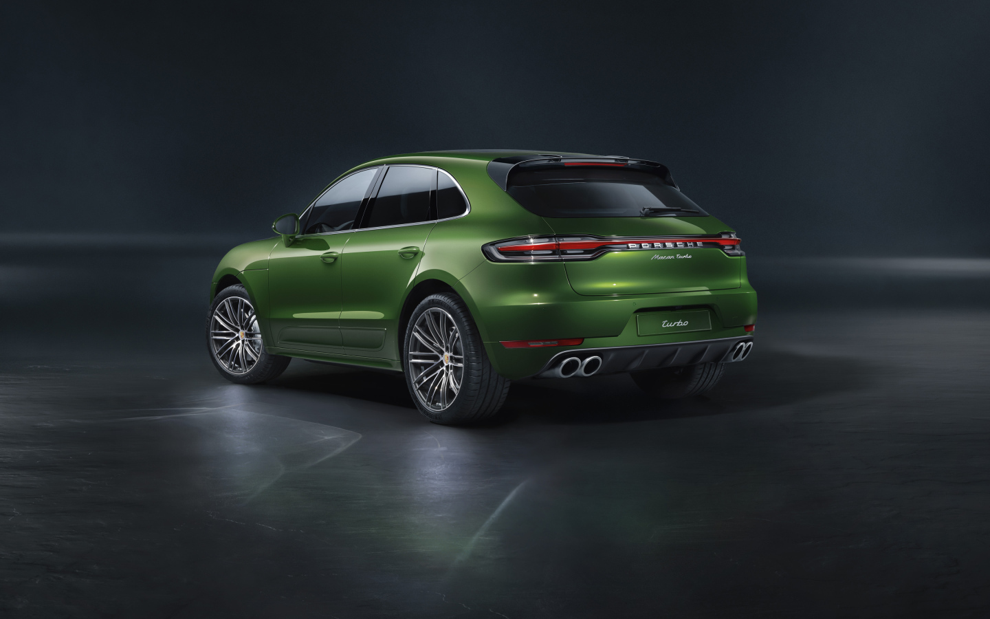 Зеленый автомобиль Porsche Macan Turbo 2019 года вид сзади