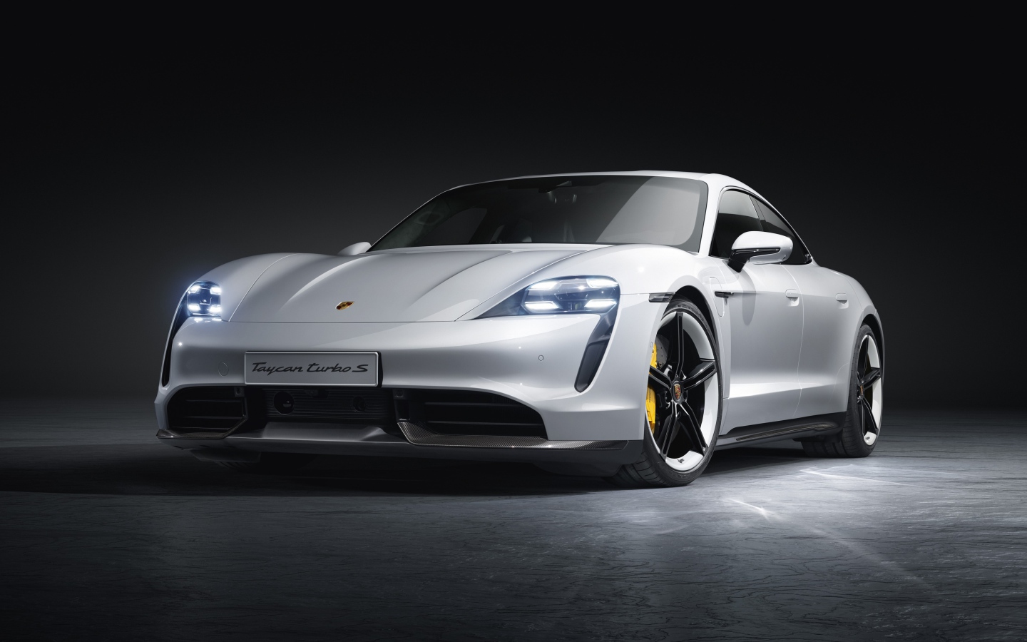 Серебристый автомобиль Porsche Taycan Turbo S 2019 года на сером фоне