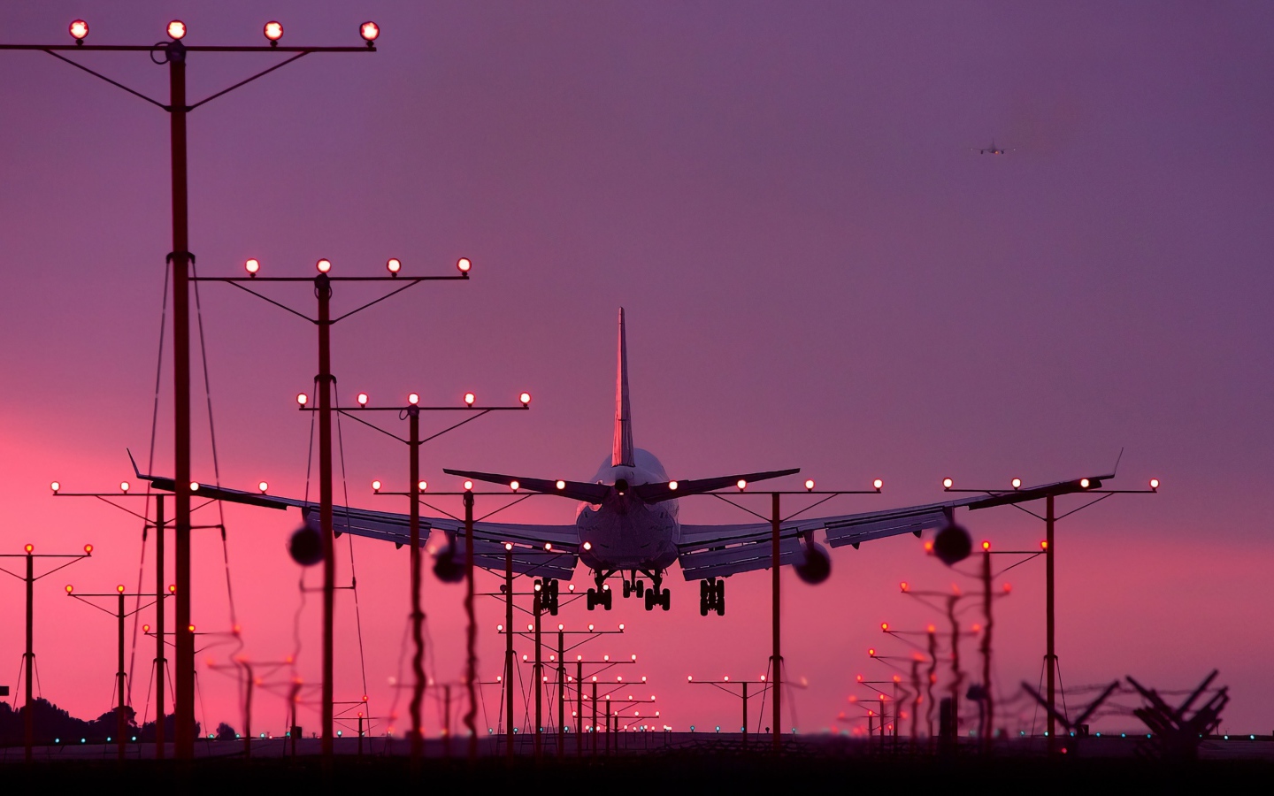 A passenger plane is landing at sunset