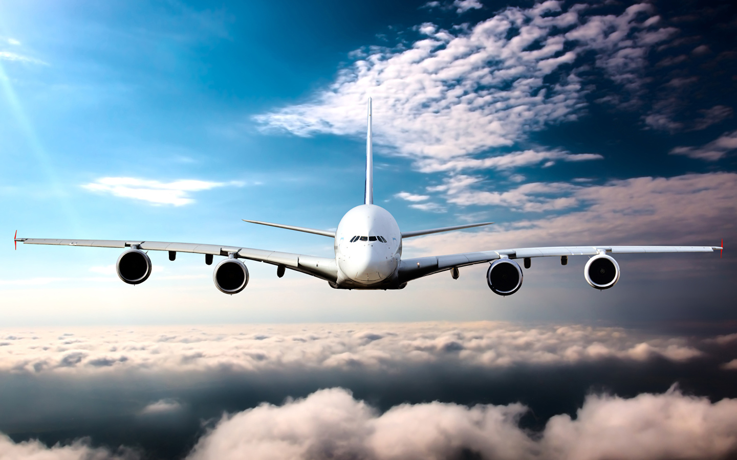 Самолет в белых облаках на фоне голубого неба