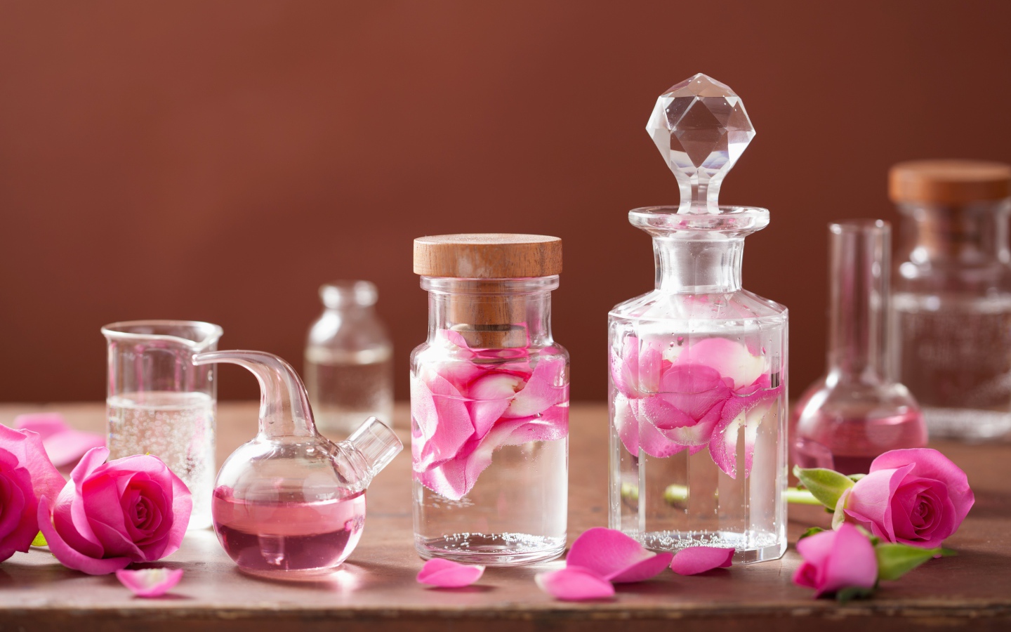 Glass bottles with fragrant water with rose petals