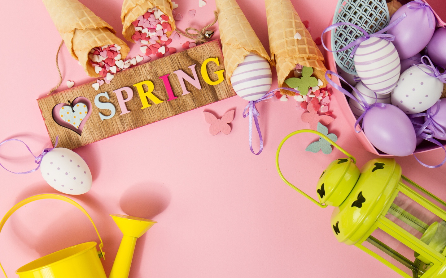 Надпись весна с вафельными рожками и яйцами на розовом фоне