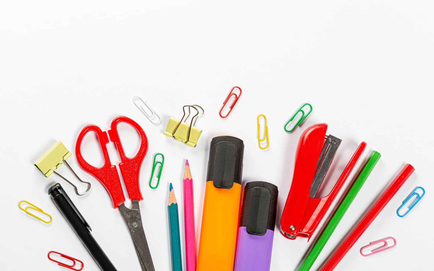 Multicolored office supplies on a white background