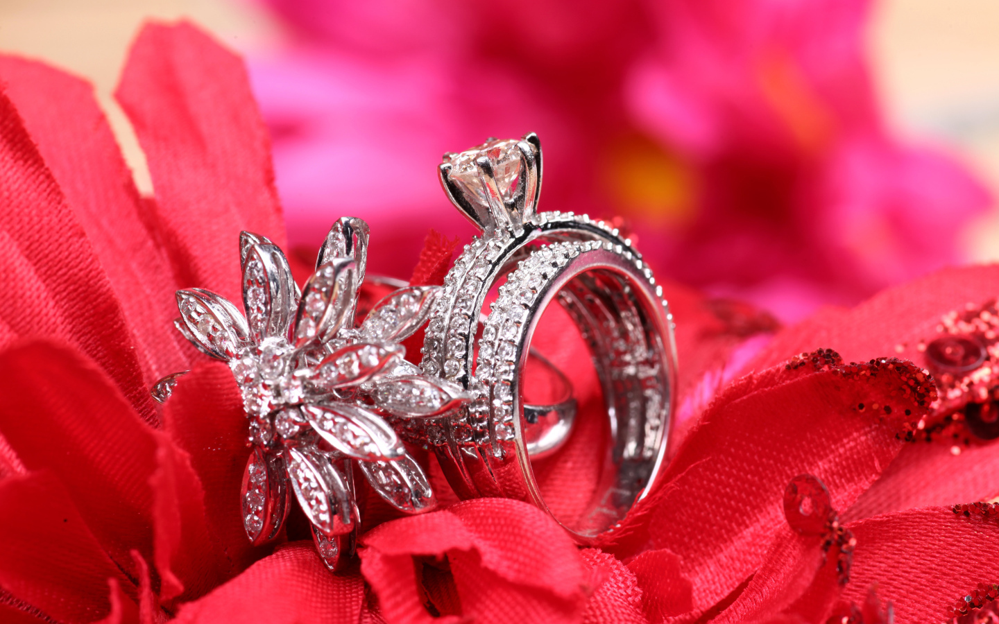 Два кольца с камнями лежат на цветке 