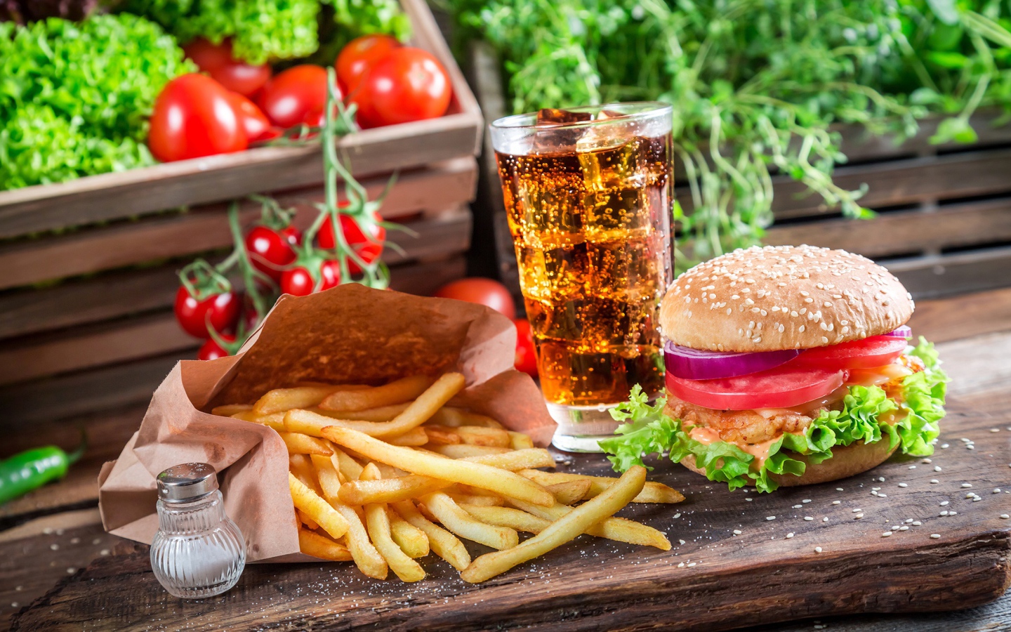 Картофель фри, гамбургер, кола и помидоры на столе