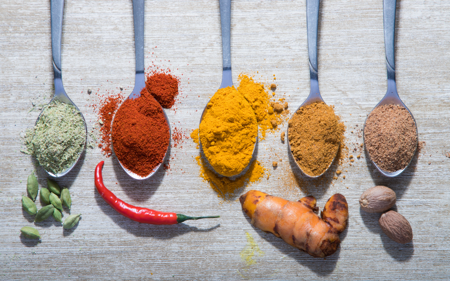 Молотые специи в ложках на столе 