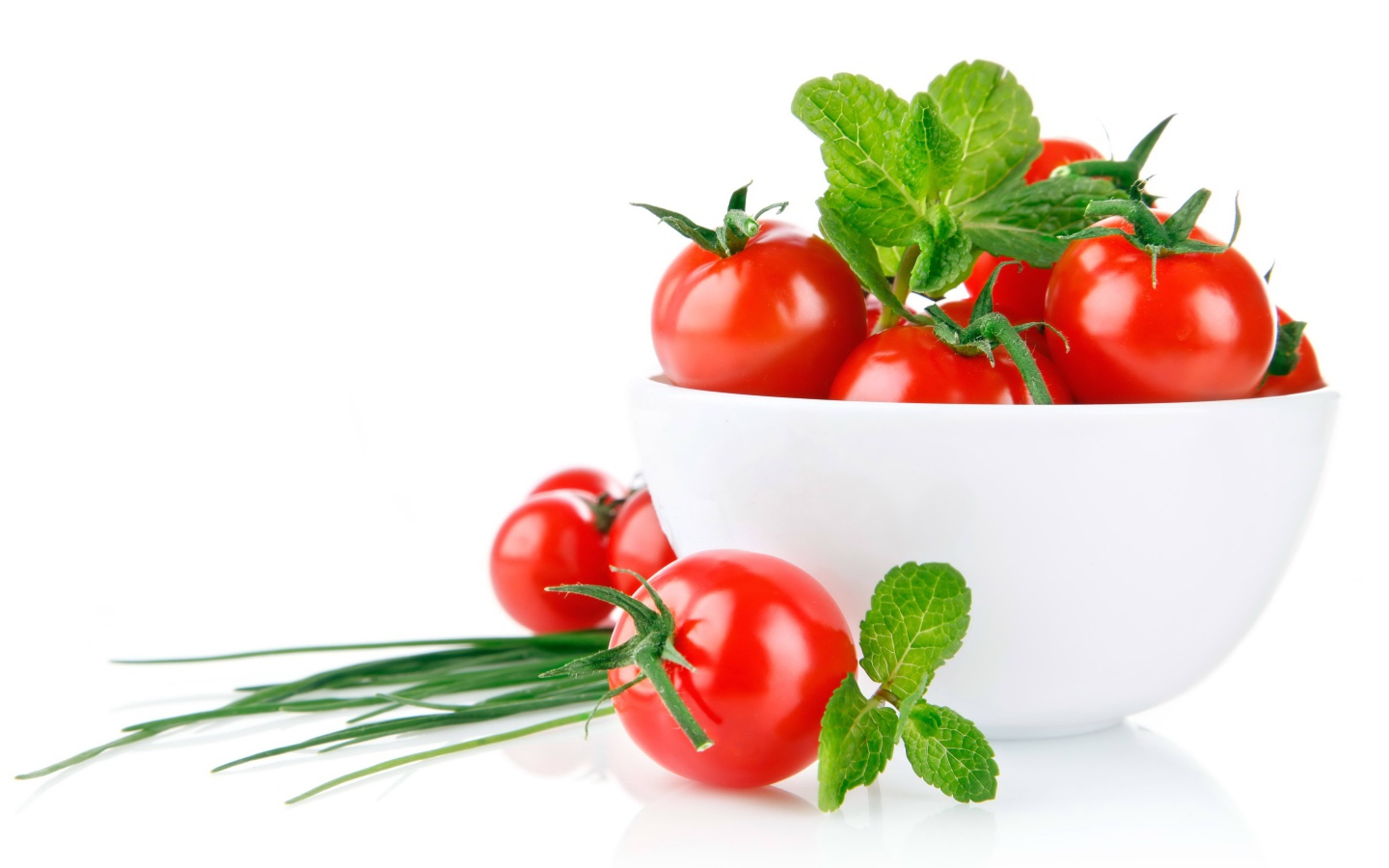 Red tomatoes with green onions on a white background