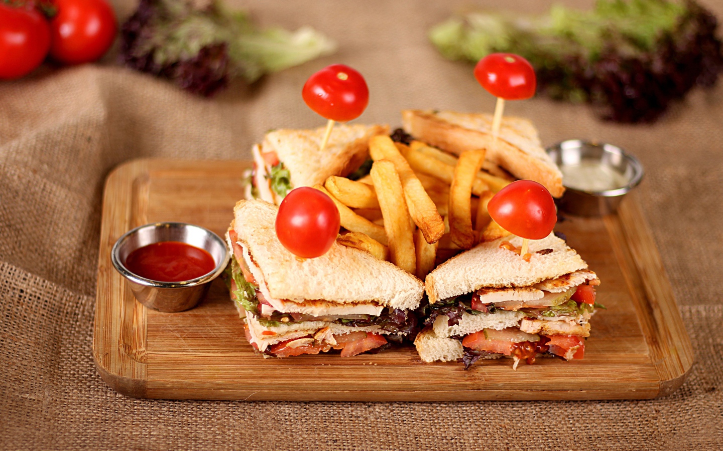 Сэндвичи на доске с картофелем фри и соусом