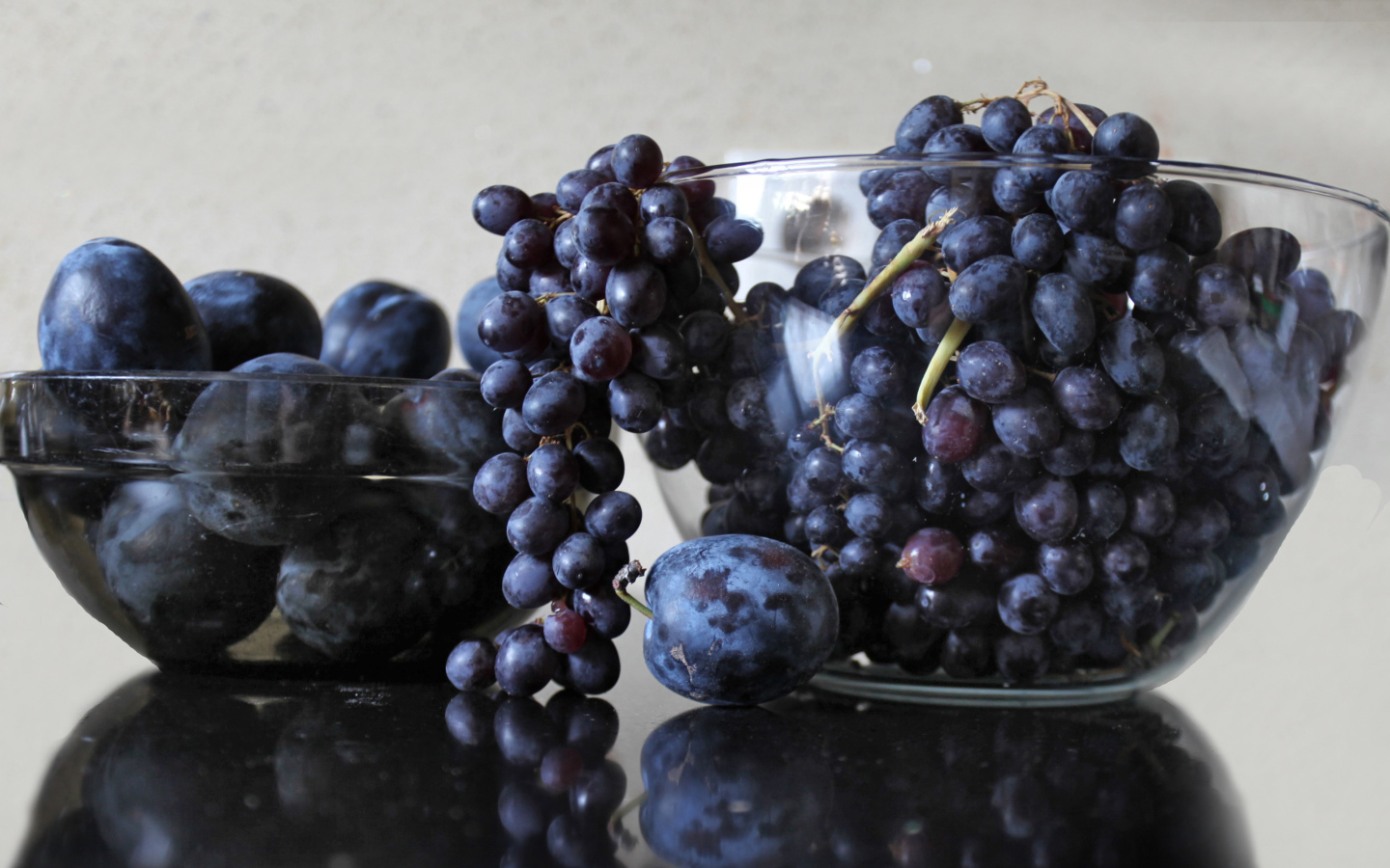 Синий виноград с синими сливами на столе