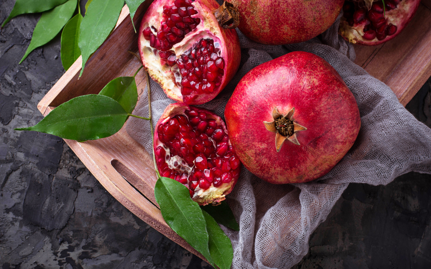 Спелые красные гранаты в деревянном ящике