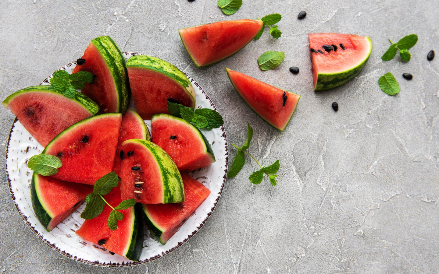 Полосатый арбуз нарезан кусочками на тарелке