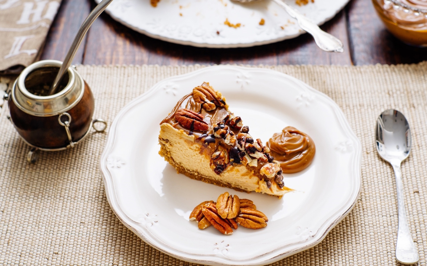 Кусок торта с орехами на белой тарелке на столе с кофе