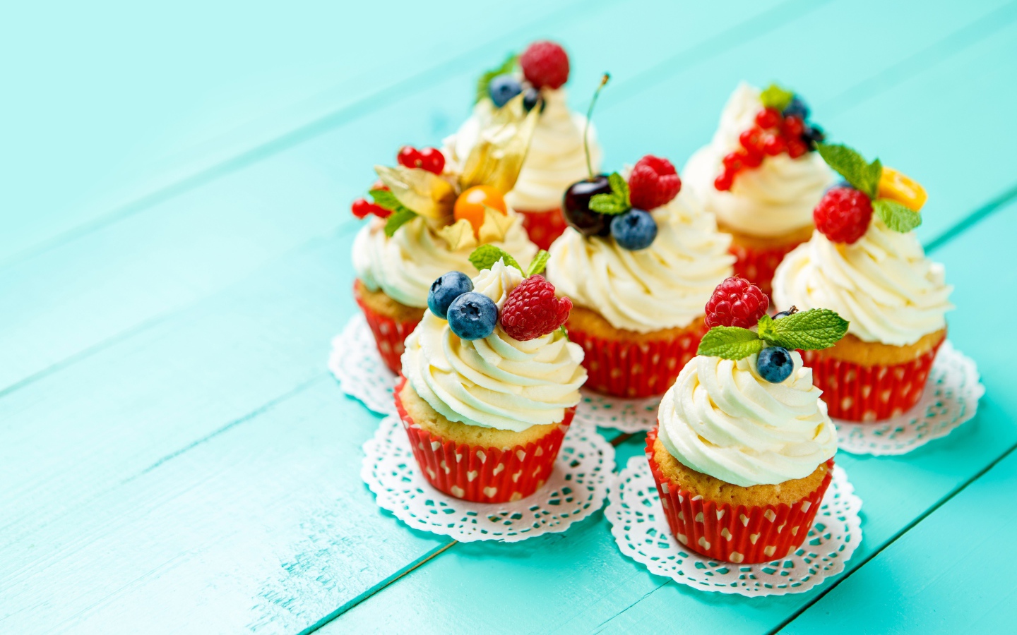 Кексы со взбитыми сливками украшены ягодами