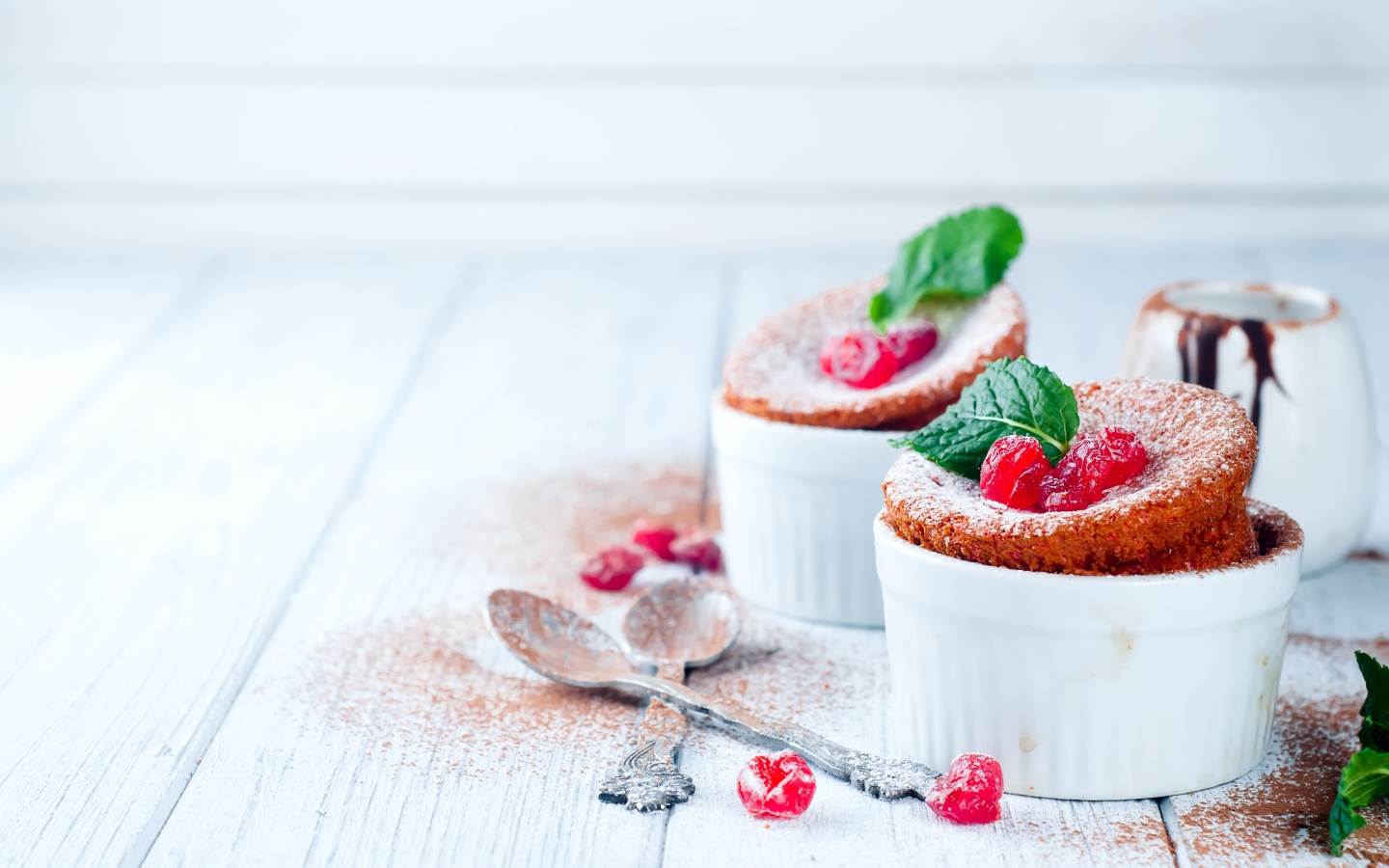 Пирожное с ягодами и сахарной пудрой на столе с ложками