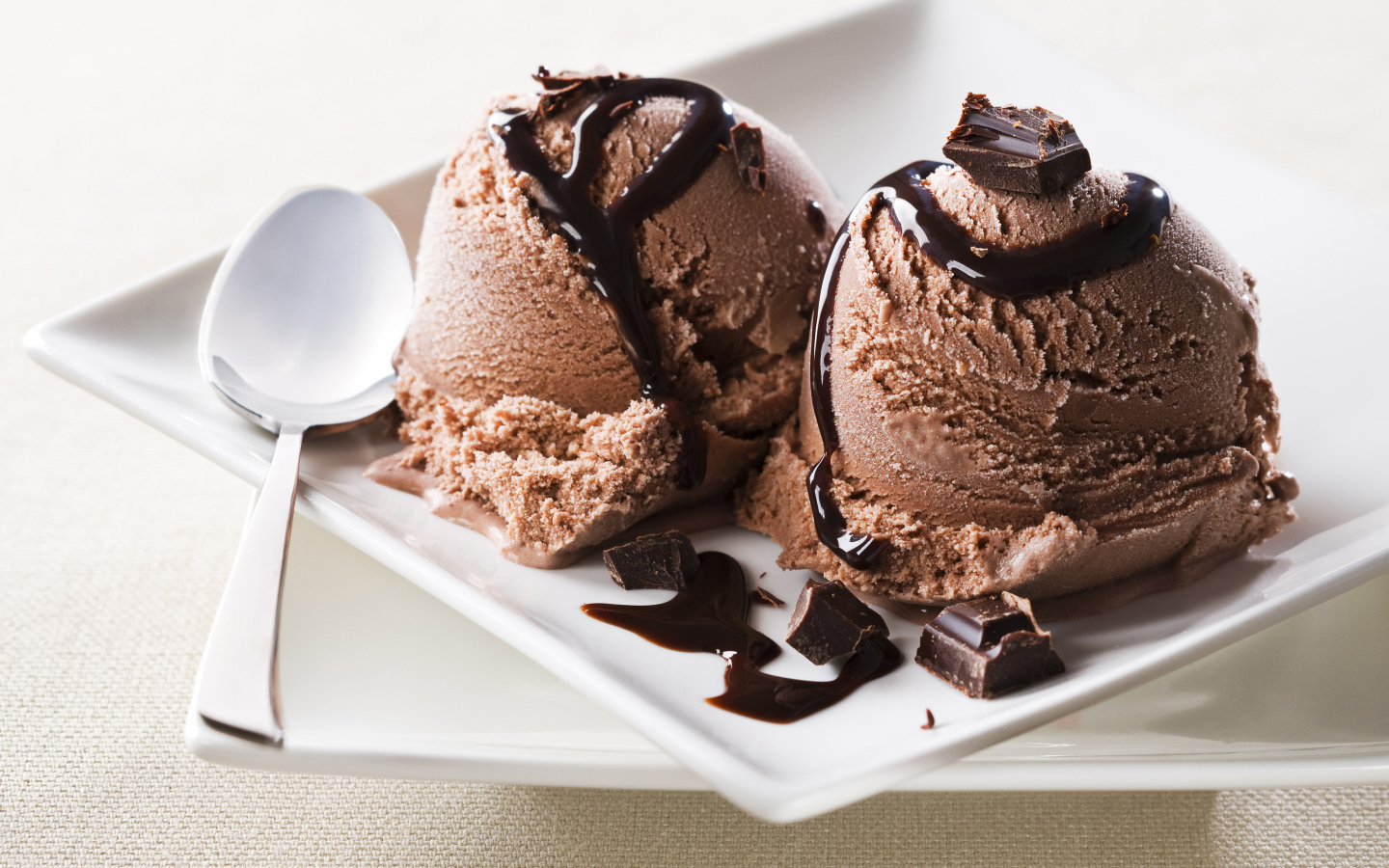 Шарики шоколадного мороженого на белой тарелке