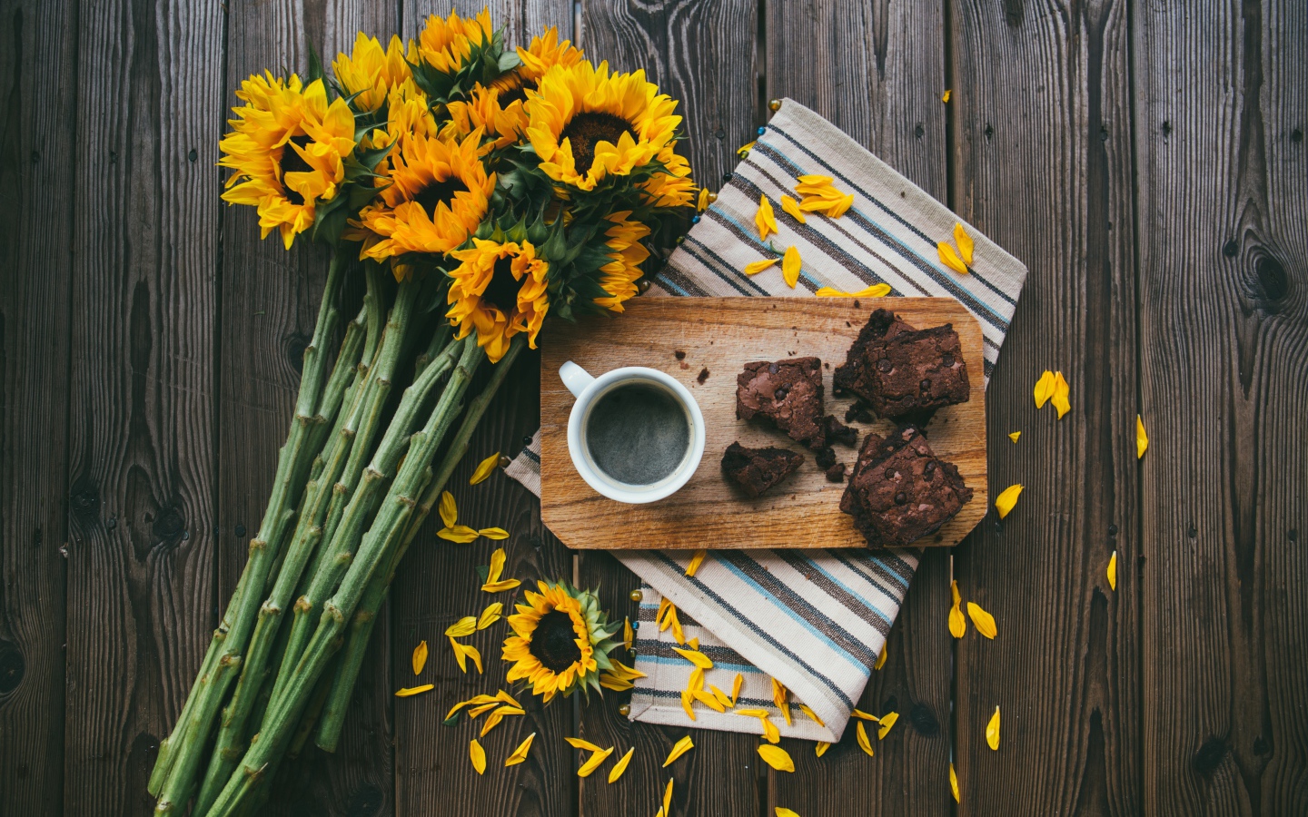 Чашка кофе на столе с пирогом и букетом подсолнухов