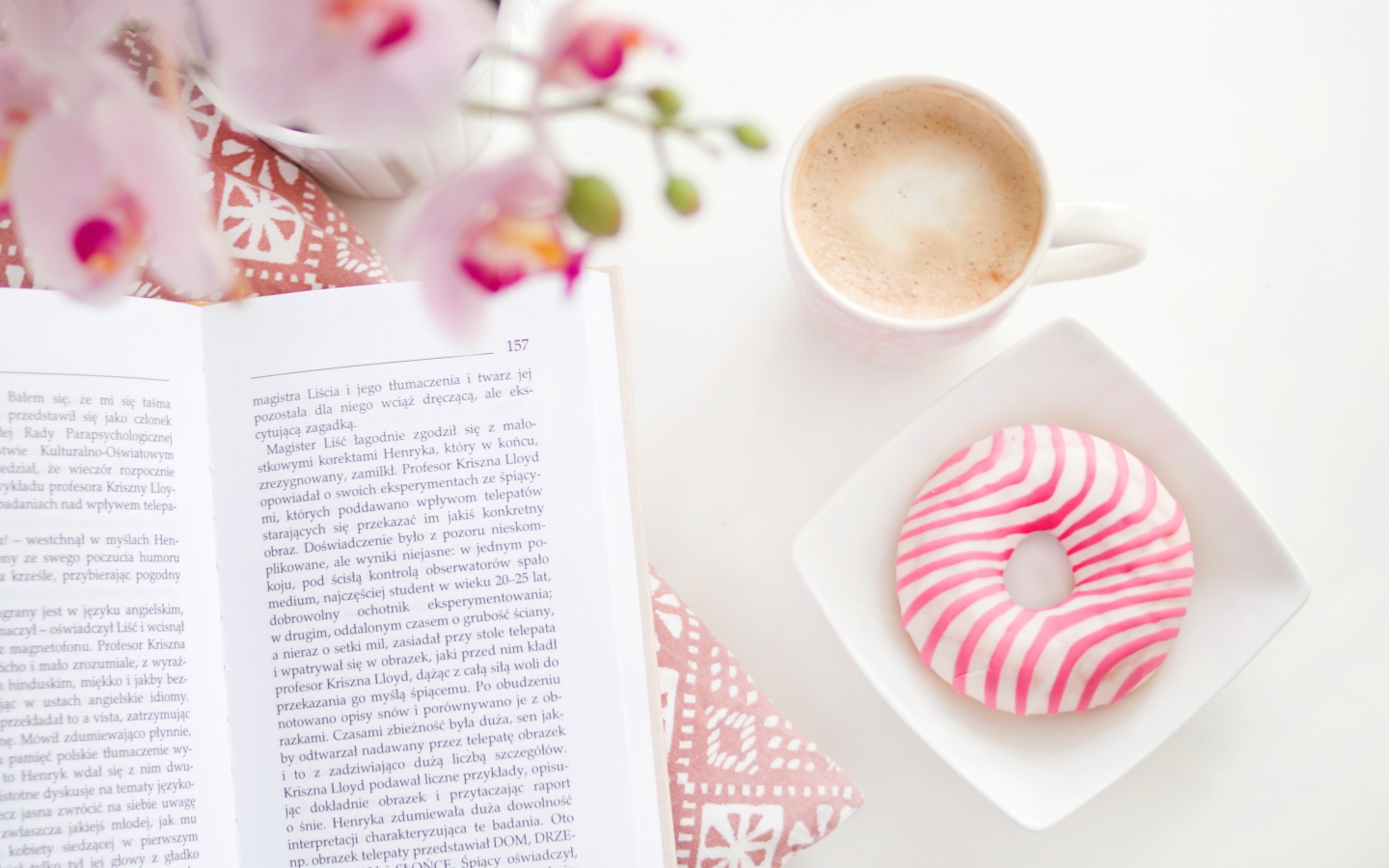 Пончик с чашкой кофе на столе с книгой