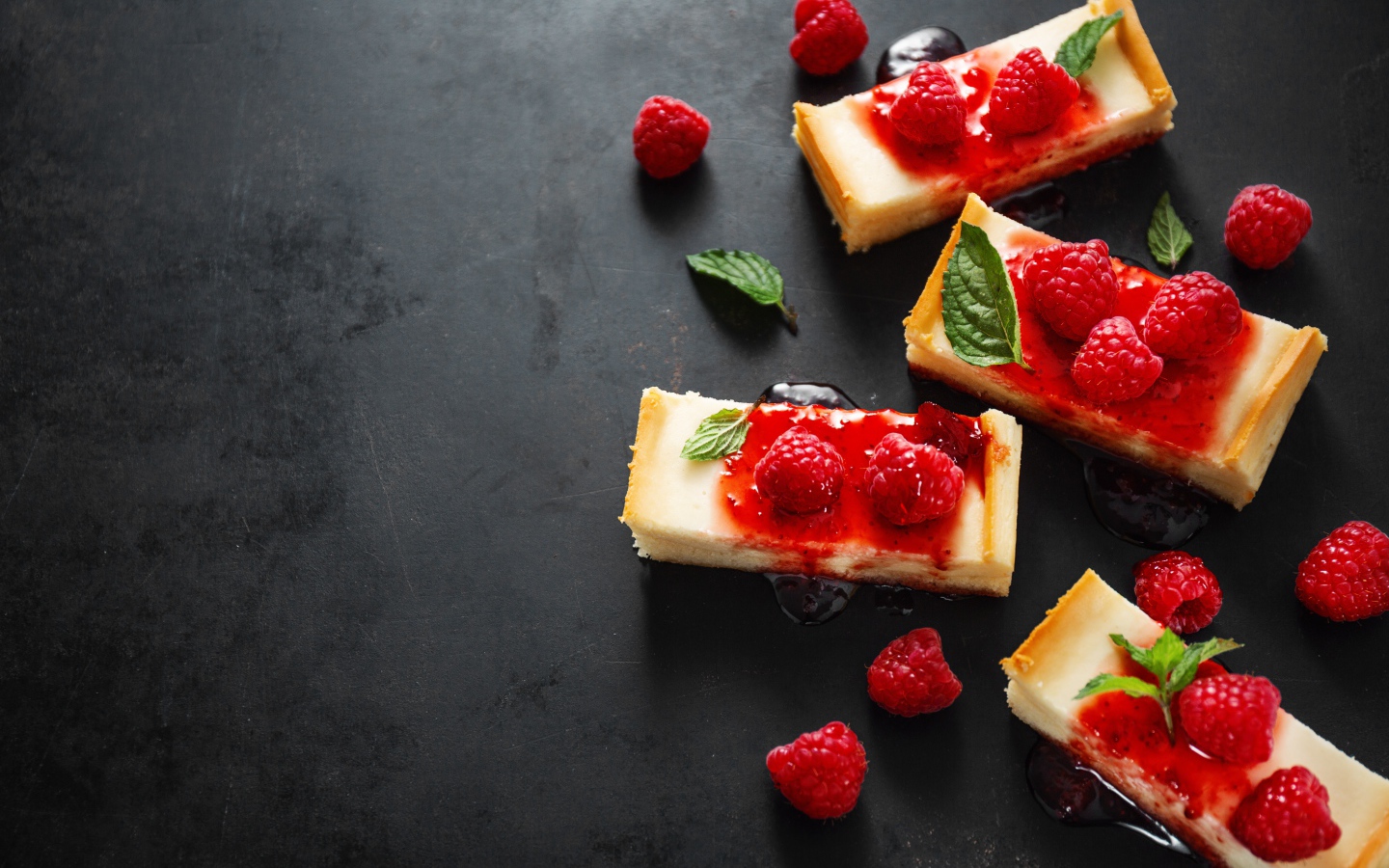 Куски чизкейка на столе с джемом и ягодами малины