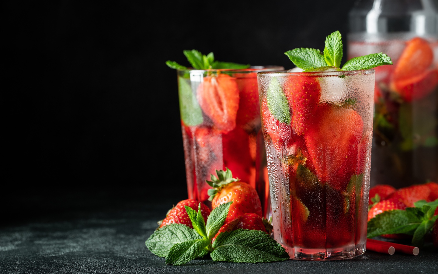 Холодный напиток в стакане на столе с клубникой и мятой