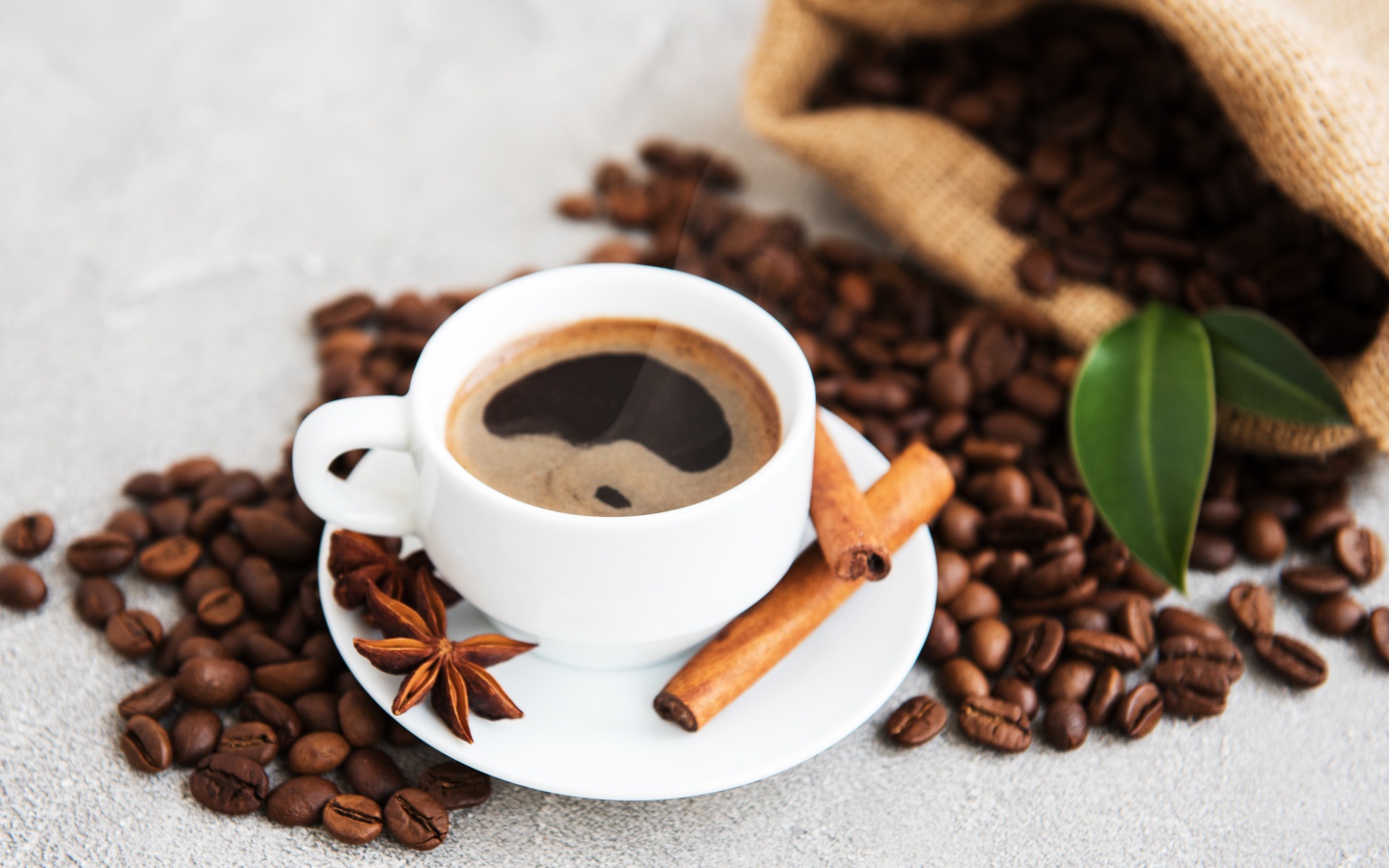Чашка кофе с корицей, бадьяном и кофейными зернами